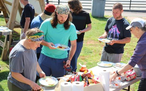 Press photo/Shelby Powell. Cody and Alex Norris prepare their lunches at the March 21 cookout.