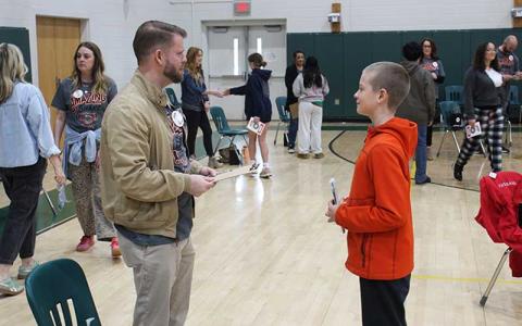 Press photo/Shelby Powell - Mountain View Intermediate students speak with volunteers for the Amazing Shake event, practicing social skills like eye contact, appearing engaged, shaking hands and making conversation. More than 600 participating students were whittled down to one winner after four days of competition across different fields and venues. Above: Student Barron Alison speaks with Ryan Cote.