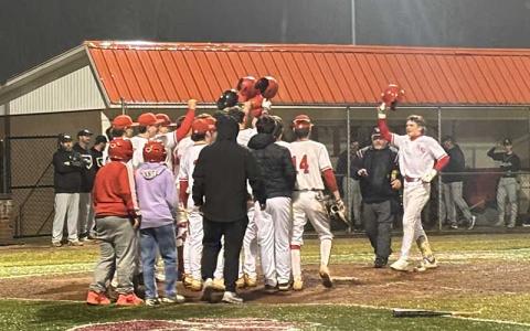 Press photo/Will Woolever - Freshman Brayden Greenwood is mobbed by teammates at home plate after belting a two-run homer in his first-ever high school game.