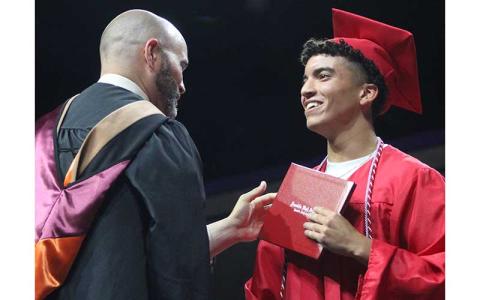 Press photo/Shelby Powell - Franklin High School graduate Samuel Roots accepts his diploma from Principal Blair King during the commencement ceremony June 5 at WCU. Roots wears a braided cord symbolizing his achievements in project management. See more photos on page on The Franklin Press Facebook page. 