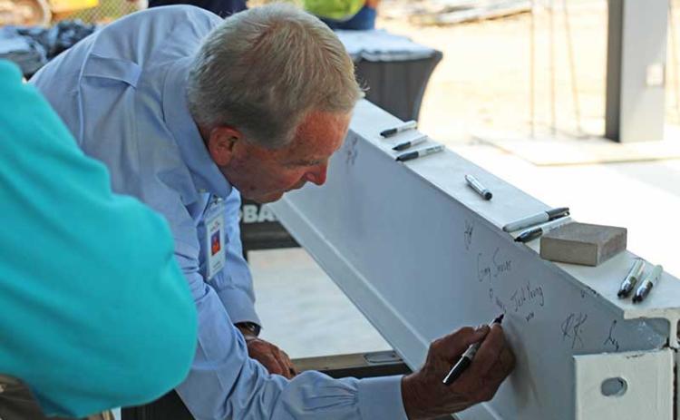 Press photo/Shelby Powell - County Commissioner Gary Shields, a former FHS principal and longtime advocate for the new high school project, is one of the first to sign his name to the beam, next to board chair Josh Young.