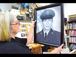 Press photo/Linda Mathias Karen Smith, chair of the Macon County Art Association’s Veterans Portraits program, unwraps a portrait of Air Force veteran Robert Lethbridge on Wednesday at the Uptown Gallery.