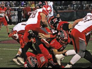 Press photo/Andy Scheidler - Franklin junior Seth Price leaps over a pile of players during last week’s game at Pisgah. It was the junior’s first game action since he broke his collarbone in September. 