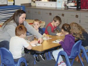 Press photo/Jake Browning - Vanessa Linn helps students with a project in her new pre-K classroom at South Macon Elementary School.