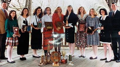 Photo submitted - The 1992 girls cross country team proudly displayed their plaques and trophies garnered during their state-championship winning season. From left: assistant coach Steve Philo, Amy Berger, Stephanie Hyder, Kristy Henson, Nikki Pons, Corie Fuchs, Marla Getford, Erica Riendeau, Jennifer Wiggins, Jessa Brown, head coach David Morgan. Not pictured: Emily Beller, Derrah Ledford.