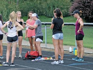 Press photo/Will Woolever Newly named head track and field coaches Kyle Brown (gray shirt, middle) and Melissa Ward (purple shirt, far right) address runners at a recent cross-country practice. 