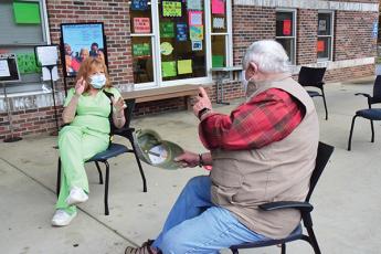 Press photo/Linda Mathias - Veteran William Talbott talks with clinic LPN Tammy Godforey.