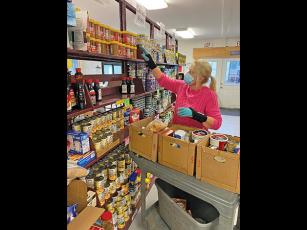 Press photo/Jake Browning - Shirl Frantz helps pack boxes of food for clients at CareNet. CareNet also hopes to distribute plenty of warm winter clothes following Cold for a Cause this weekend.