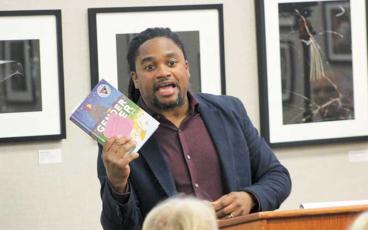 Press photo/Thomas Sherrill - Commissioner Danny Antoine holds up a copy of the book “Gender Queer,” as an example of “filth” that is available for kids in the Macon County Public Library during a Feb. 7 meeting.