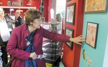 Press photo/Thomas Sherrill - N.C. Secretary of State Elaine Marshall looks at a 1950s menu on display at the Motor Company Grill during a Monday tour of small businesses in downtown Franklin. Marshall also visited The Kitchen Sink and Outdoor 76 during her visit.