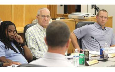Press photo/Thomas Sherrill - County Commissioners Danny Antoine, Paul Higdon and Josh Young talk with County Manager Derek Roland about the budget during the June 13 board meeting. The board recessed the meeting and will reconvene on June 19.