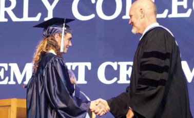 Press photo/Thomas Sherrill - Superintendent Chris Baldwin shakes the hand of Anika Ruth Zuiderveen of Macon Early College during the school’s graduation ceremony on June 4. After 50 total graduations as superintendent, Zuiderveen was the last Macon County high school graduate Baldwin shook hands with before his retirement.