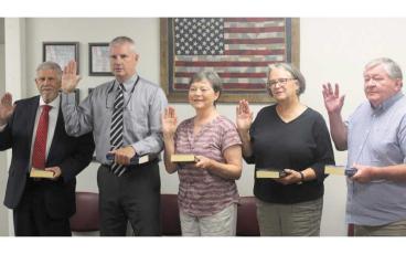 Press photo/Thomas Sherrill - Jeff Gillette, John Vanhook, Kathy Tinsley, Lynne Harrison and Gary Dills take the oath of office for another term on the Macon County Board of Elections prior to the board’s July 18 meeting. Tinsley was re-appointed as board chair for another year.