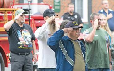 Press photo/Thomas Sherrill - Veterans salute the American flag during a singing of the National Anthem at Monday morning’s 9/11 remembrance event in downtown Franklin. 