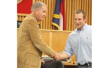 Press photo/Thomas Sherrill - Commissioner Josh Young (right) congratulates Commissioner Gary Shields on his election as board chair for the next year at the Dec. 12 meeting. Young was then elected as vice chair.
