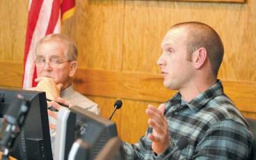 Press photo/Thomas Sherrill - Commissioner Josh Young speaks to GeoServices’ Danny Williams during the Jan. 9 Macon County Board of Commissioners meeting, as Board Chair Gary Shields looks on.