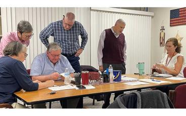 Press photo/Mia Overton - Macon County Board of Elections members tally the early votes on Primary Election Night, March 5. Pictured are Chair Kathy Tinsley, Lynne Garrison, Gary Dills, John Vanhook, Jeff Gillette and Board of Elections Director Melanie Thibault.