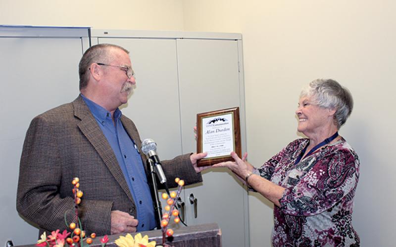 Press photos/Jake Browning - Kathy Kahler presents Alan Durden with a plaque marking his 30 years as cooperative extension director.