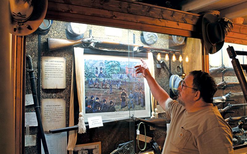 Press photo/Will Woolever - Macon County Historical Museum curator Robert Shook explains the history behind Civil War artifacts in the museum’s collection. The museum will unveil a new exhibit – an original 19th century log cabin – next door to its building in November.