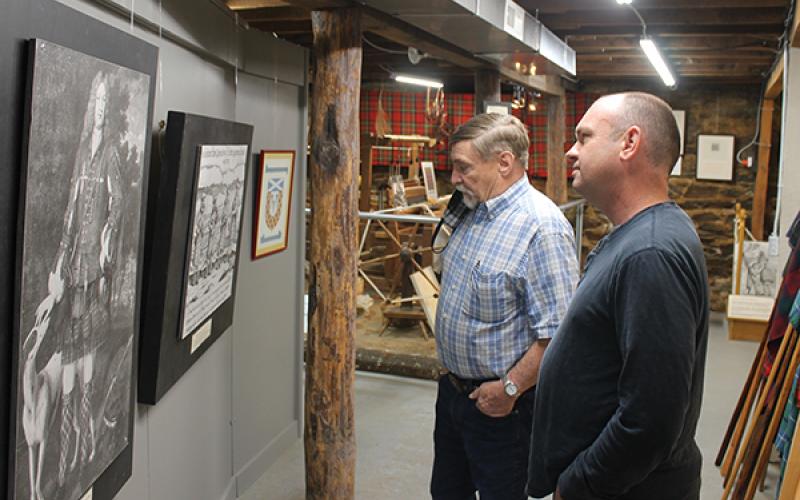 Press photo/Will Woolever - Scottish Tartan Museum director Jim Akins and new Blair Building owner Stacy Guffey examine a piece of artwork in the museum’s basement.