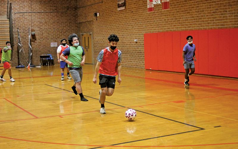 Press Photo/Will Woolever - Junior striker Luis Torres lines up a shot in a recent practice while goalkeeper Isaac Jennings (left) and defender/midfielder Flady Mendoza (background) look on. Torres recorded a rare ‘hat trick’, or three goals in a single game, against Brevard Feb. 11.