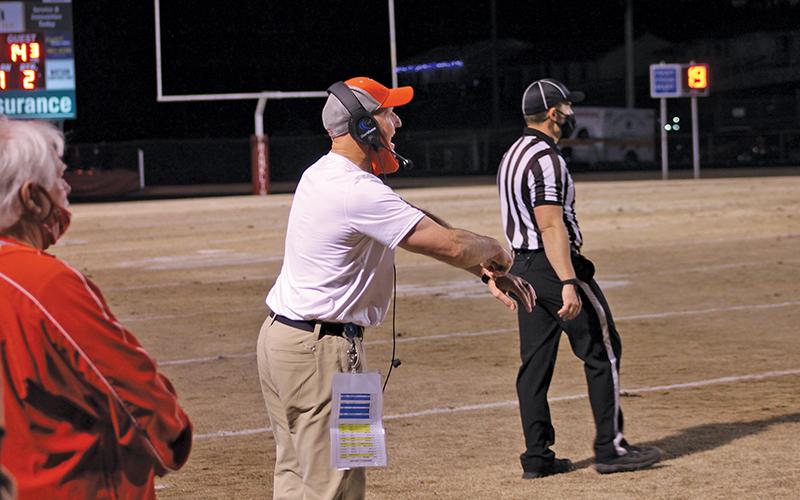 File photo - Longtime FHS football coach Josh Brooks coaches up his players from the sideline against Hendersonville March 12.
