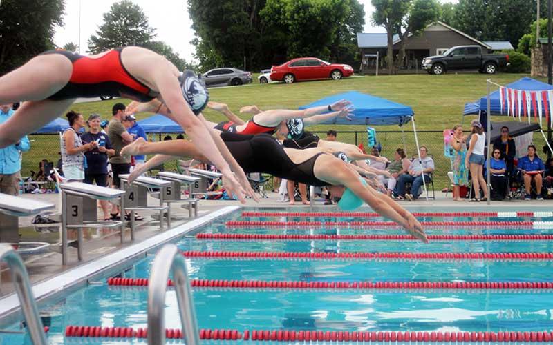 Press photo/Will Woolever - Girls 15-18 standout Claire Ballard (center) dives off the block for the 200-yard individual medley against the Cherokee County Aquatic Club June 15. 