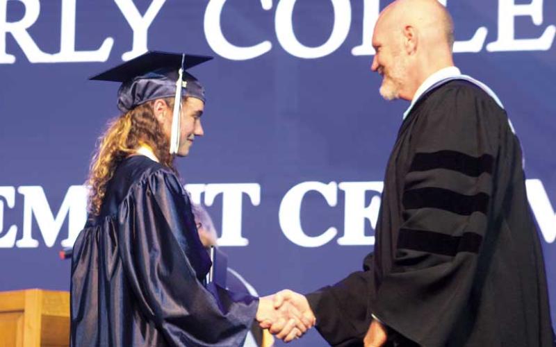 Press photo/Thomas Sherrill - Superintendent Chris Baldwin shakes the hand of Anika Ruth Zuiderveen of Macon Early College during the school’s graduation ceremony on June 4. After 50 total graduations as superintendent, Zuiderveen was the last Macon County high school graduate Baldwin shook hands with before his retirement.
