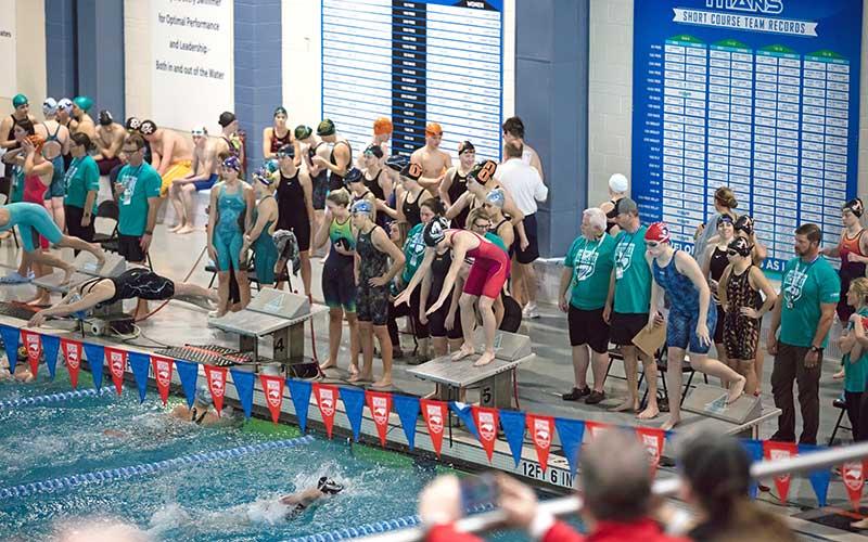 (Photo courtesy of Amy Ballard) Senior Rylee Cassada (far right) waits for Zoi Walker to touch the wall in the women’s 200-yard freestyle relay Feb. 8. 